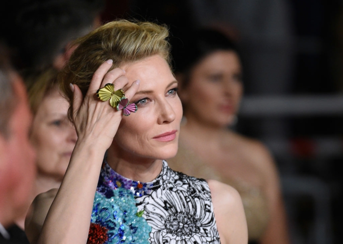 Cate Blanchett, chignon élégant, bagues avec papillons colorés, robe unique bariolée, imprimés floraux