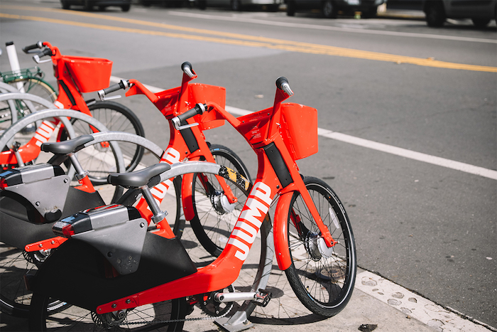 vélo uber en rouge et noir sur un trottoir, vélo libre service autonome développée par uber avec les avancées de la robotique