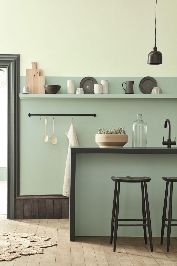 modèle de cuisine aux murs vert pastel, agencement cuisine verte avec accents noirs, mur de couleur vert celadon