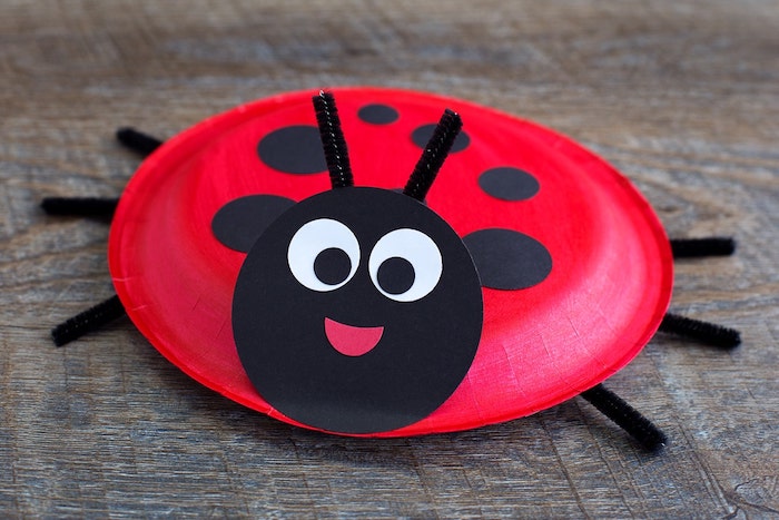 idée de recyclage d assiette jetable en papier rouge décoré de pois noirs et tête en cercle noir motif coccinelle avec antennes et pattes en cure pipe, activité manuelle printemps