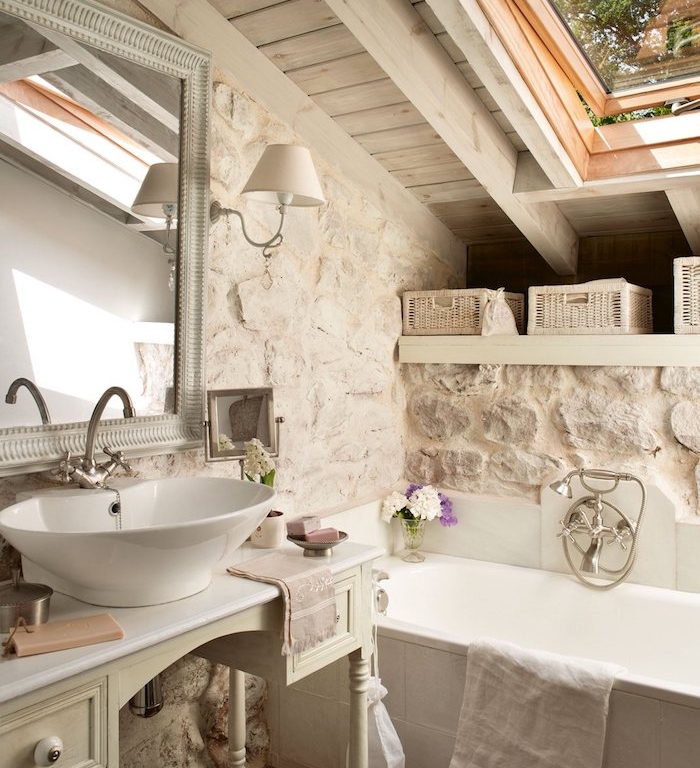 mur de pierres, baignoire blanche, lavabo à poser sur console meuble ancien salle de bain, miroir vintage, idee salle de bain rustique campagne chic
