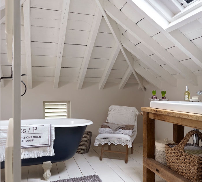 salle de bain mansardée sous plafond en bois blanchi, parquet bois blanchi, baignoire bleu nuit, lavabo blanc dans meuble salle de bain rustique