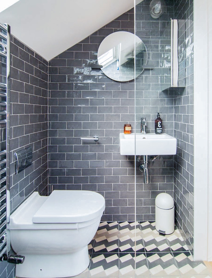 idée de douche sous pente en couleur grise dans une petite salle d eau avec wc blanc, miroir rond et paroi vitré