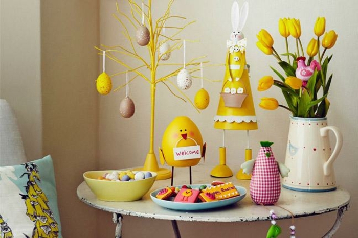 decoration de table en jaune avec objets vintage, arbre de pâques, petite table ovale