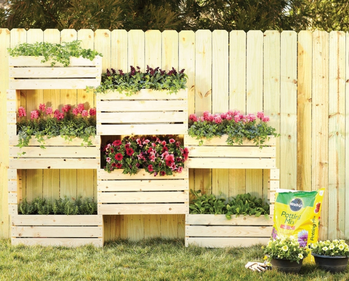 aménager un petit jardin en hauteur avec une structure en bois portant des bacs à planter fleuris