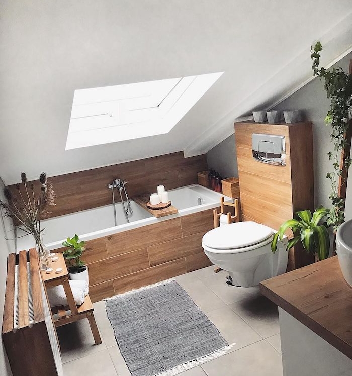 baignoire avec revetement de bois pour une touche rustique, wc suspendu, tapis gris sur carrelage gris, salle de bain zen, ambiance spa