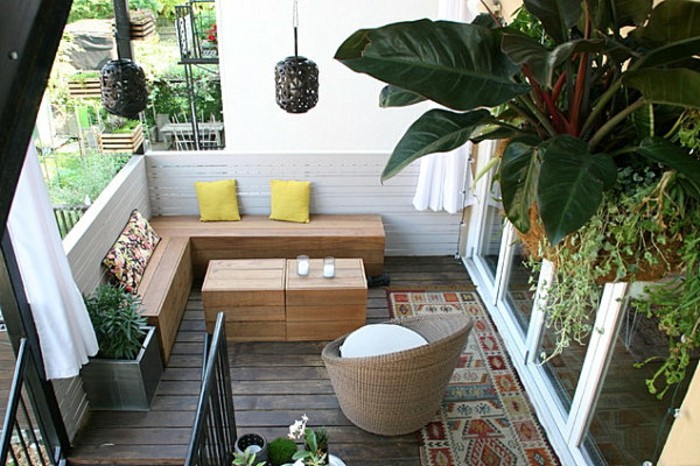 canapé d angle bois avec une table bois basse, parquet bois usé, garde corps en planches de bois blanchies, plantes suspendues, fauteuil rotin