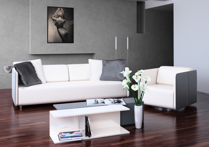 aménagement salon aux murs à texture béton, mobilier salon moderne avec fauteuil canapé et double table basse en blanc et gris