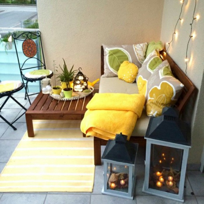 idée de table et canapé bois marron avec deco de coussin d assise grise et coussins decoratifs gris, jaune et vert, tapis jaune, lanternes decoratives