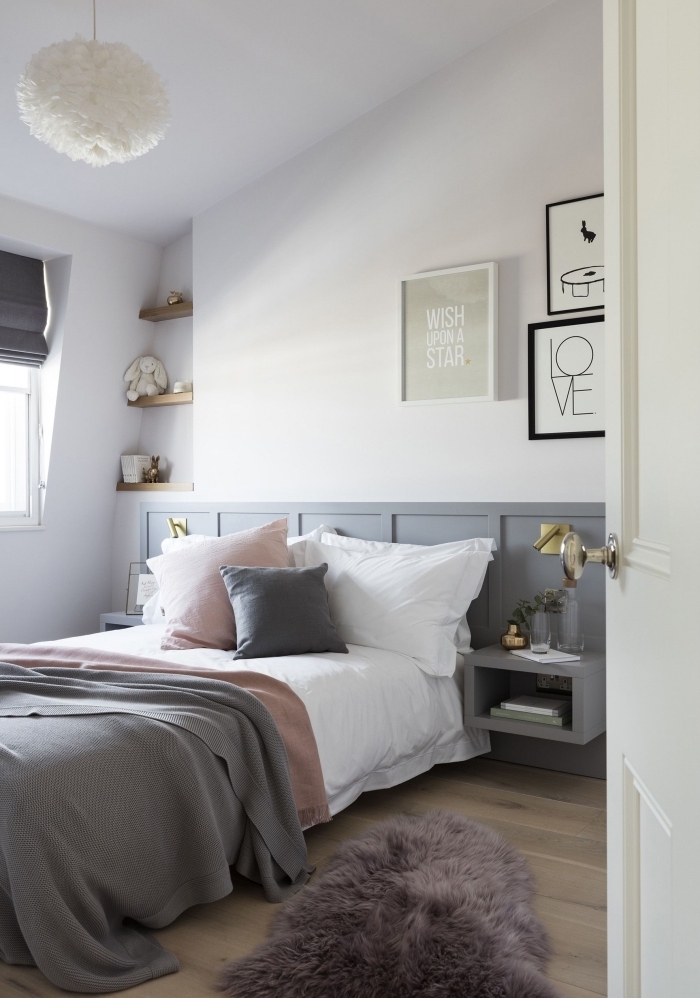 un soubassement bois peint en gris qui fait office de tête de lit avec des tables de nuit intégrées dans une chambre à coucher style scandinave