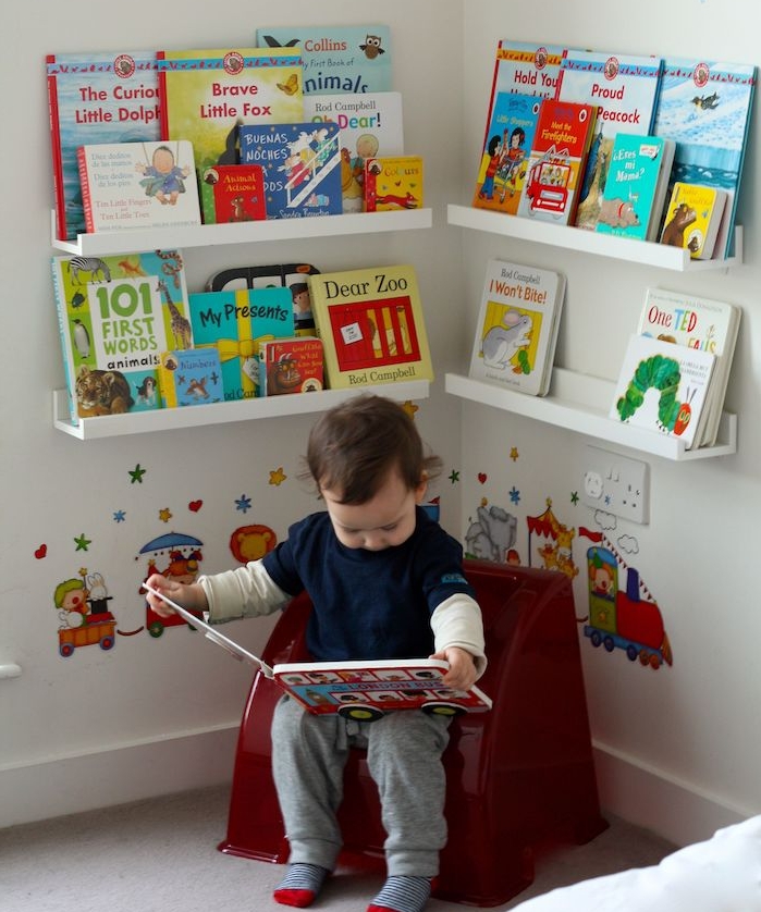 coin lecture montessori jeux avec petit fauteuil enfant et livres rangés sur etagres basses, deco sticker chambre enfant