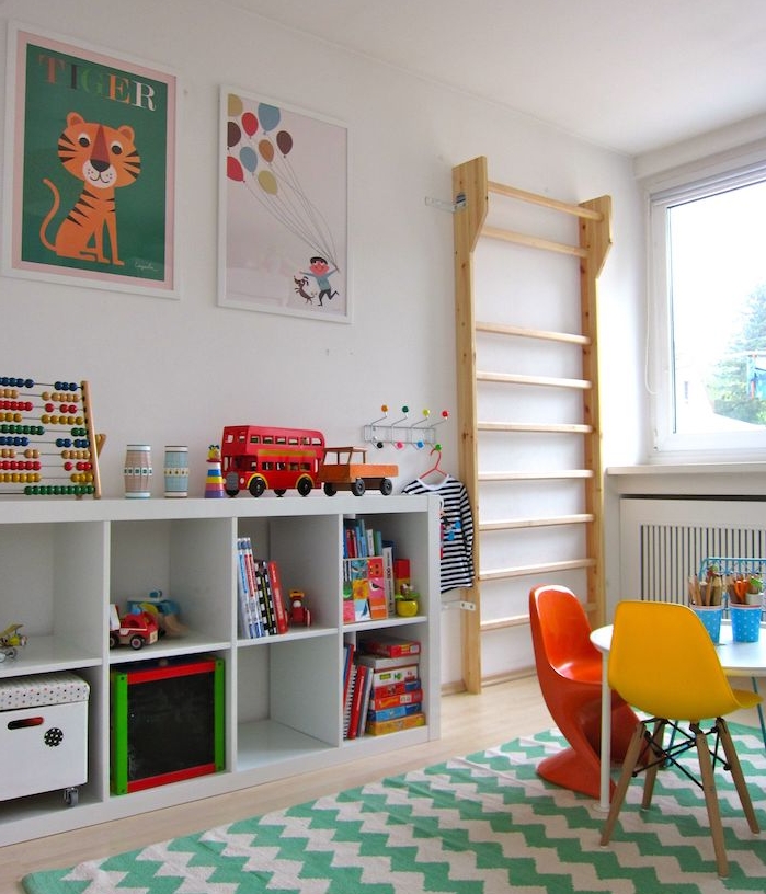 etagere kallax blanche pour la chambre enfant, pédagogie montessori à la maison, tapis chevron vert et blanc, table et chaises basses, jouets et affiches enfant sur mur