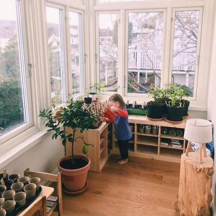 coin vert enfant sur la terrasse couverte, méthode montessori à la maison, apprendre à l enfant à jardiner et s'occuper des plantes, photo enfant en train d arroser plantes