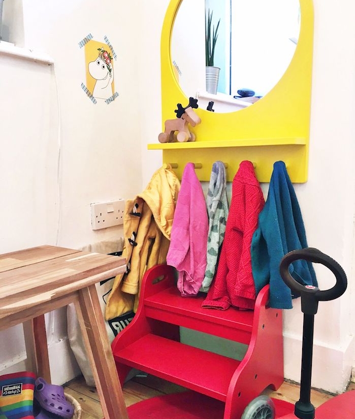 amenagement entree enfant avec petit banc enfant rouge, miroir jaune et porte-manteau bas