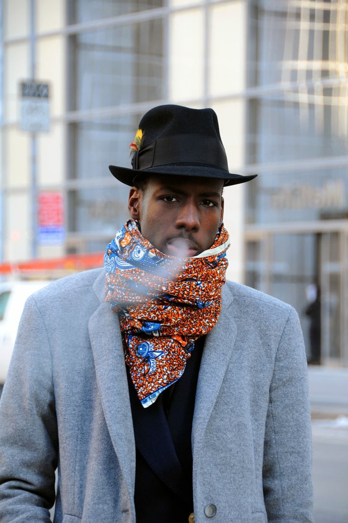 écharpe bariolée aux motifs bleus et oranges, veste gris clair, chapeau cylindre, vetement africain homme