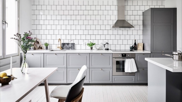 déco de cuisine traditionnelle avec revêtement mural en carreaux blancs et plancher bois blanc, exemples meubles haut cuisine en gris