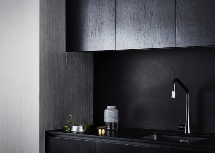 exemple de cuisine gris et noir moderne, modèle comptoir noir, idée revêtement mural à effet texture bois gris