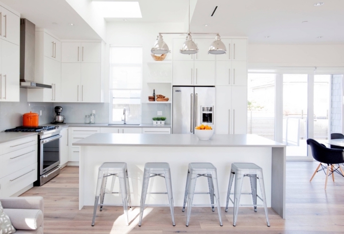 exemple de cuisine grise et blanche, déco de cuisine en l avec îlot, pièce au plancher bois et murs blancs avec meubles gris clair