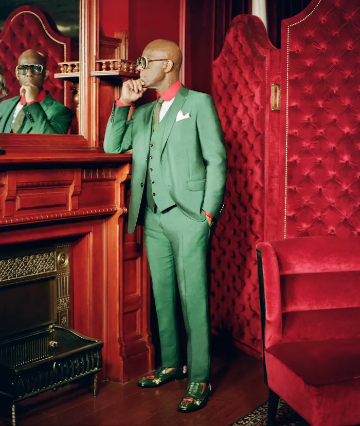 Dapper Dan dans un costume vert sur fond de velours rouge pour collaboration Gucci
