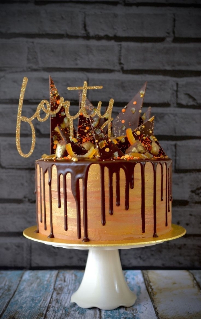un gâteau d'anniversaire 40 ans au glaçage coulant de chocolat, orné de copeaux en chocolat et de zestes d'orange confits