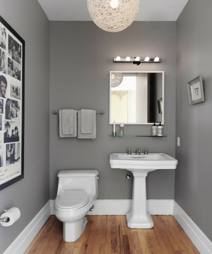 amenagement wc gris et blanc, sol en bois, grand luminaire, miroir ancadré, étagère en verre, photos monochromes
