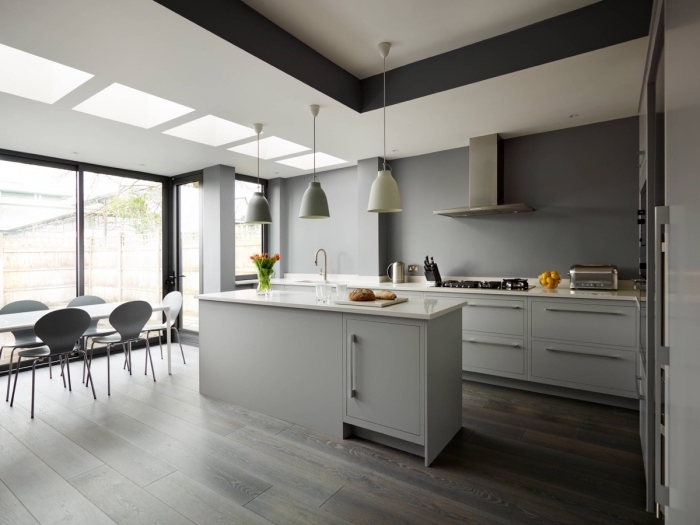 modele de cuisine moderne aux murs gris avec plafond blanc, aménagement cuisine avec table à manger et îlot