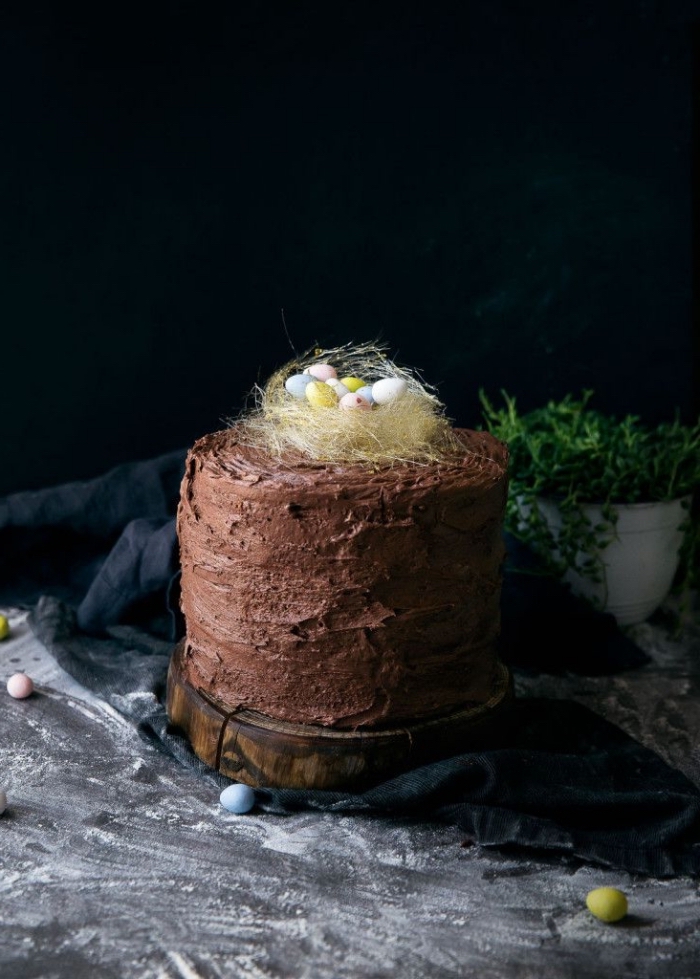 recette de layer cake nid de paques composé de trois génoises vanille fourrés de la crème au beurre et chocolat décoré d'un petit nid en sucre filé et de mini-oeufs de pâques en chocolat