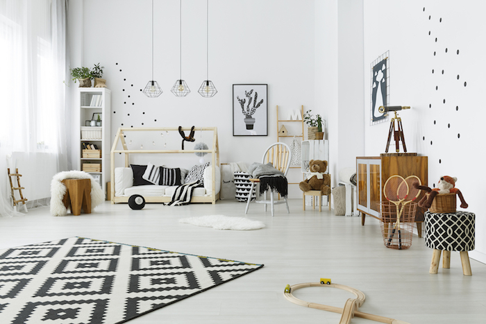 exemple amenagemet chambre montessori scandinave en noir et blanc et mobilier enfant en bois, parquet bois clair, tapis noir et blanc, echelle decorative, commode basse