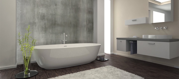 design intérieur moderne dans une salle de bain beige et blanc avec sol foncé et pan de mur à texture béton ciré