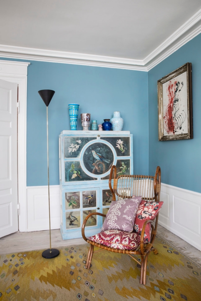 salon de style éclectique avec des murs couleur bleu sarcelle mis en valeur par une moulure murale blanche
