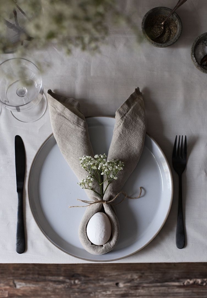 une belle table de pâques naturelle de style rustique, serviette en lin en forme de lapin paques