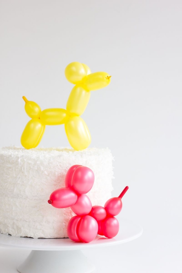 gateau anniversaire enfant au glaçage de crème beurre et noix de coco décoré avec deux petites sculptures sur ballons 