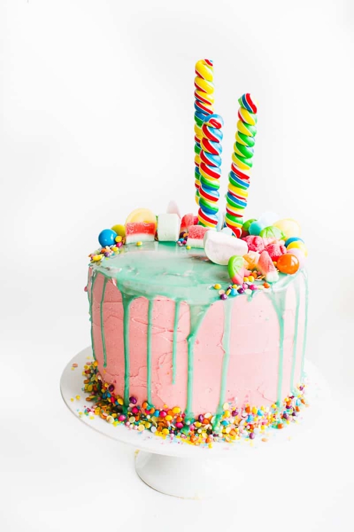 gateau anniversaire enfant original au glaçage coulant vert avec pleins de bonbons colorés, de perles en sucre et de sucettes