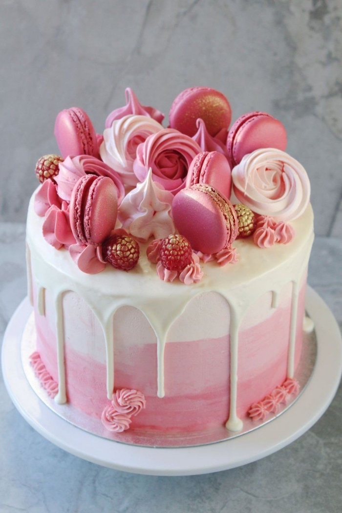 décoration de gâteau de meringues croquantes, macarons, framboises et petites fleurs en glaçage rose, décoration de gateau d'anniversaire facile