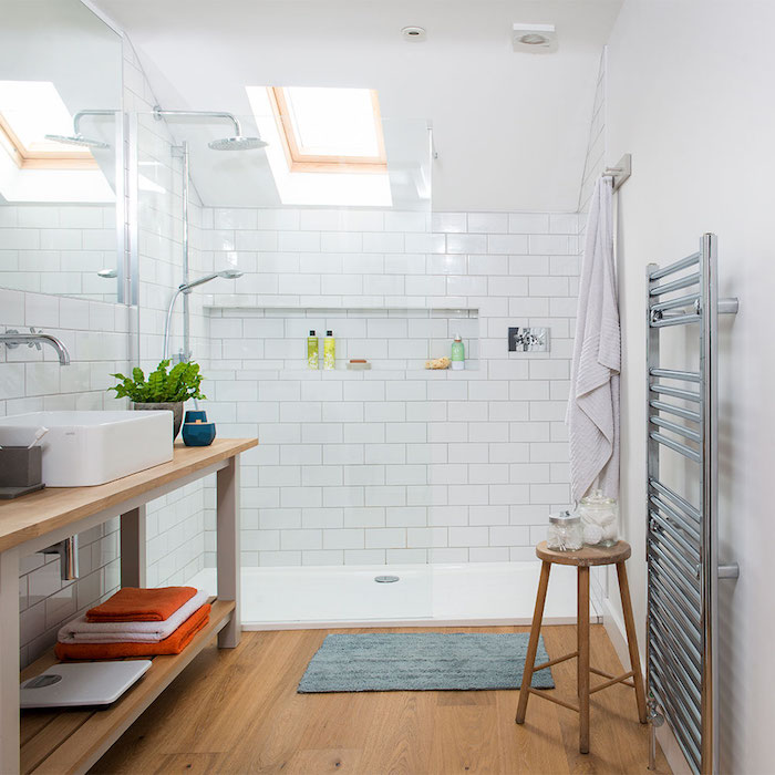 vasque à poser blanche sur meuble salle de bain bois avec étagères de rangement, parquet bois, douche avec carrelage blanc