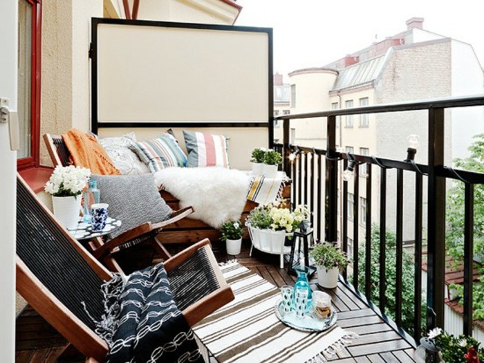 comment aménager son balcon avec des chaises de bois pliantes et banc de bois foncé décoré de coussins décoratifs, revêtement terrasse bois composite