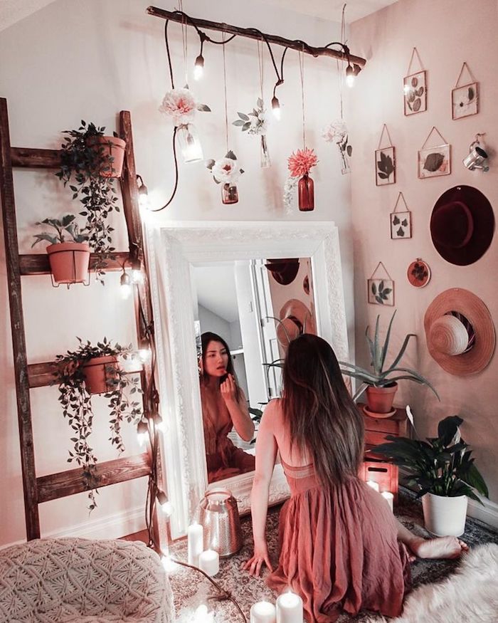 Fille qui se regarde dans le miroir et fait son maquillage, rose robe, échelle rangement fleurs, feuilles dans cadres