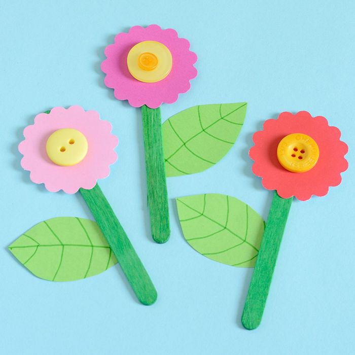 fleur en batonnet de glace, feuilles de papier et fleur en papier coloré avec centre en bouton jaune, activités manuelles maternelle