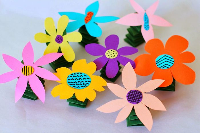 fleur en tige de papier plié en accordeon et fleur de papier coloré avec un centre en cercle de papier coloré à motifs variés
