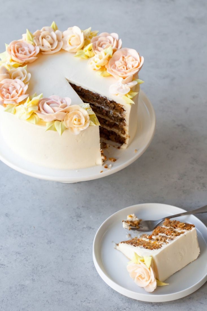 des fleurs en pâte d'amande qui décorent le dessus d'un gâteau d'anniversaire au glaçage lisse de crème beurre, gateau facile et original avec un joli décor en pâte d'amande