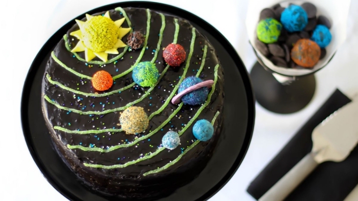 gateau facile et original au glaçage noir sur thème système solaire orné de petites boules en pâte à sucre imitant les planètes