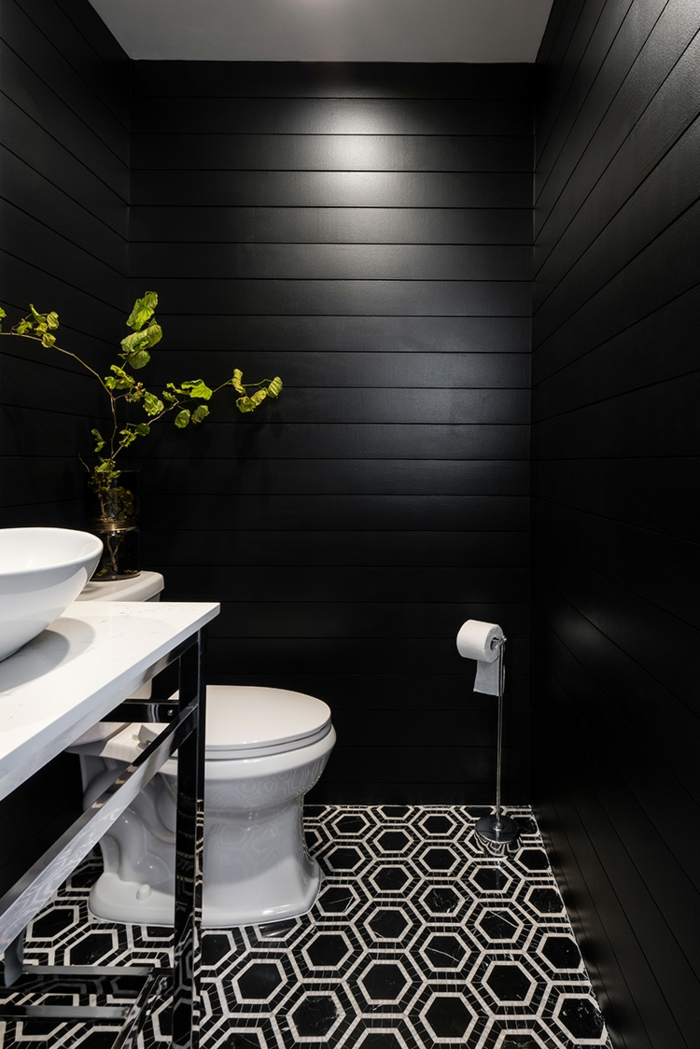 deco toilettes originales, sol aux motifs géométriques, plante décorative, vasque à poser blanche, lambris mural noir