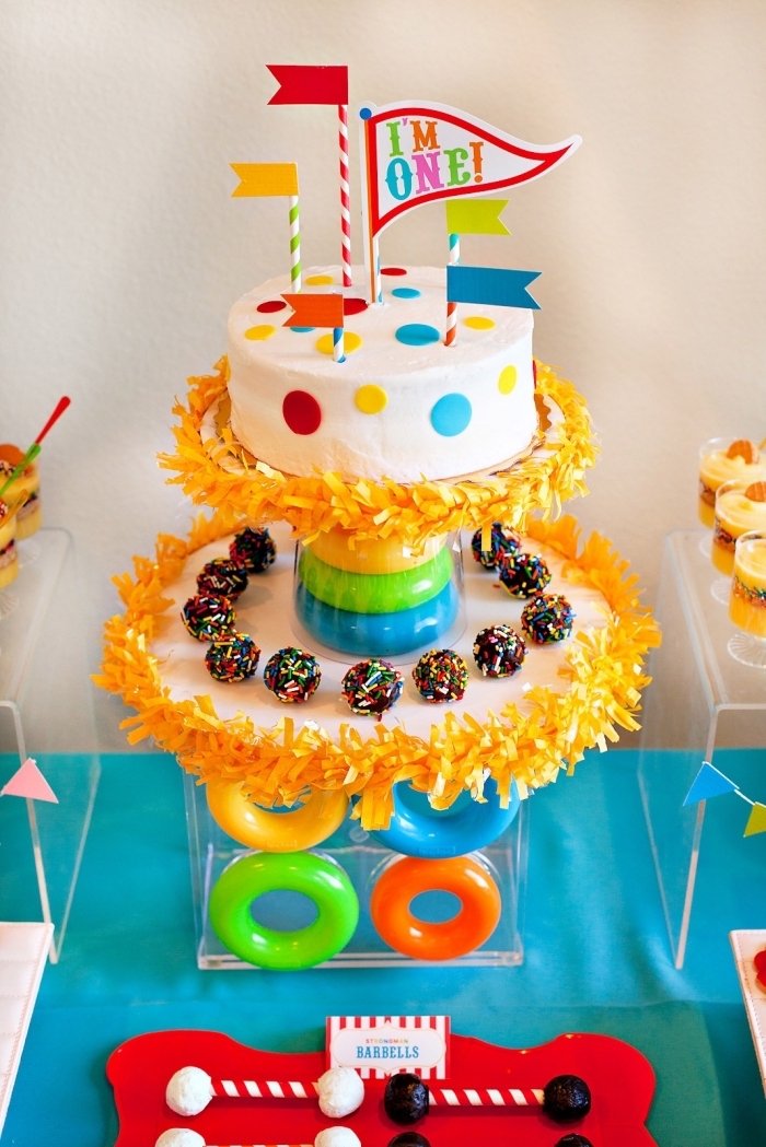 un gâteau enfant sur le theme anniversaire cirque, gâteau d'anniversaire au glaçage lisse blanc orné de petits ronds en pâte à sucre