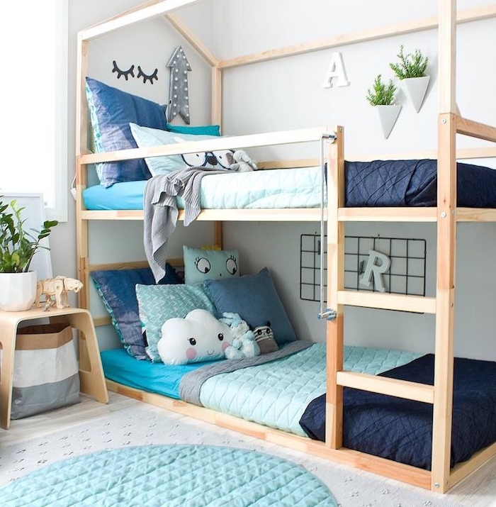 lits superposées en bois style scandinave pour gain de place dans la chambre montessori, linge de lit bleu, table de nuit bois, tapis rond bleu