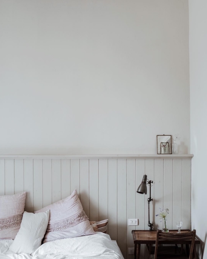chambre à coucher de style vintage avec une tête de lit en lambris blanc avec espace rangement, peindre du lambris dans la même couleur que le mur pour un effet harmonieux dans la déco
