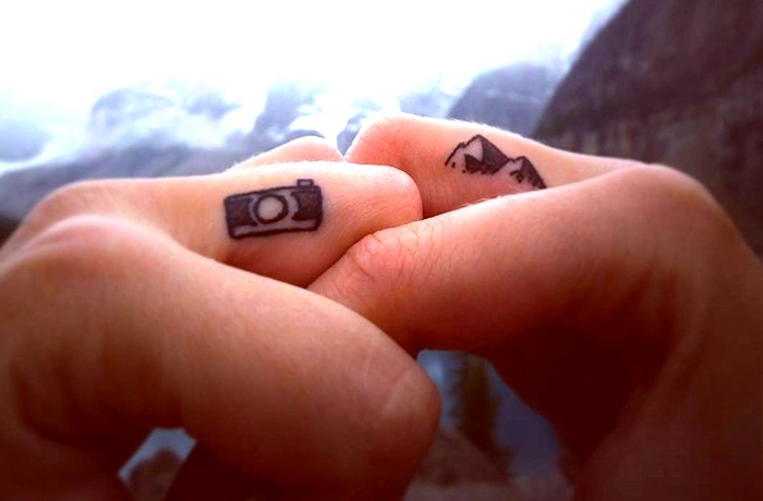 idée de tatouage doigt sur le thème du voyage aux design appareil photo et montagne, tatouage femme aventurière