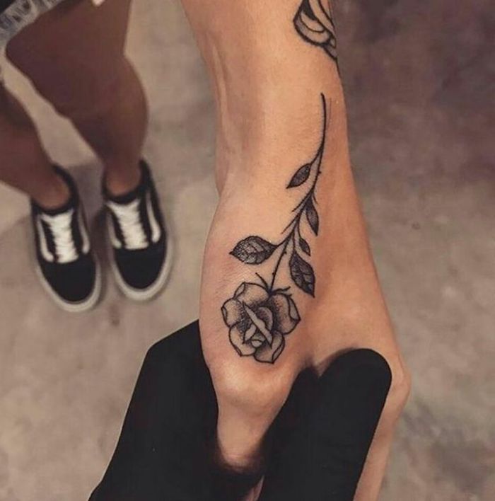tatouage main rose qui monte vers la base de la pouce, choix d'un tatouage inspirant et riche en symbolisme pour une femme