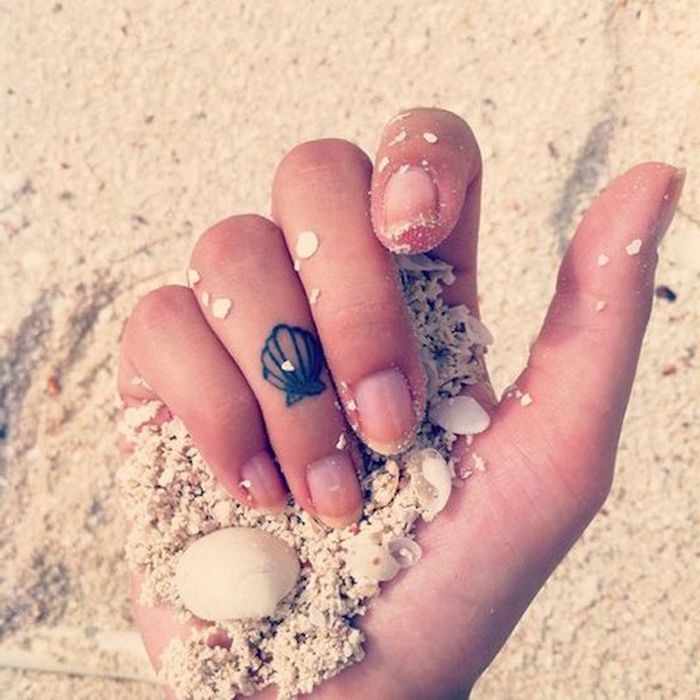 tatouage doigt de coquillage minimaliste réalisé sur l'annulaire, tatouage pour femme d'inspiration la mer