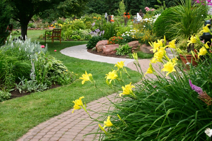 massif fleures, allée de jardin, petit ilot de pierres dans un jardin paysager, lys jaunes
