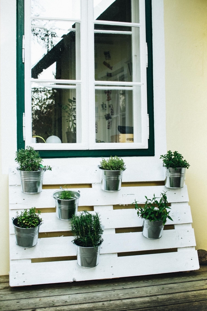 des pots en zinc fixés sur une palette recyclée repeinte en blanc, aménager un jardin en hauteur grâce à une palette de bois